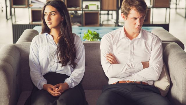 Resentful young man and woman look away from each other on couch