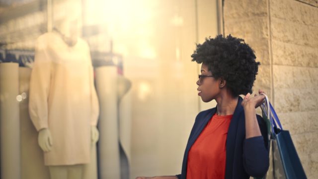 young black woman looking in store window
