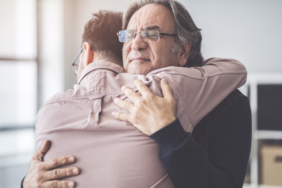 father hugs his adult son