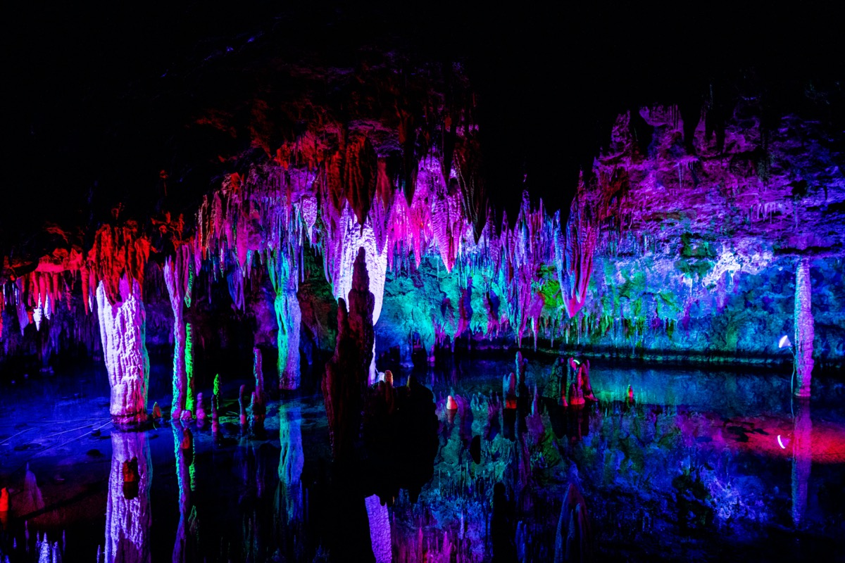 colorful light illuminates the rock formations inside meramec cavern
