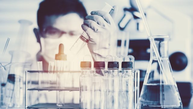 scientist with test tubes in a lab about to make a major breakthrough