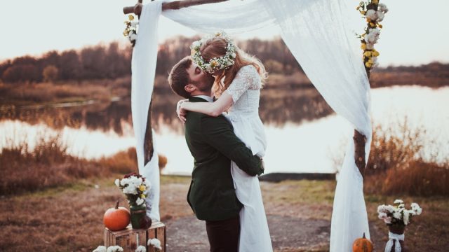 bride and groom kissing at a rustic wedding