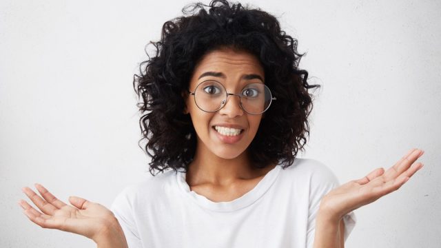 female wearing white T-shirt, feeling guilty, confused, making helpless gesture with hands, having Oops expression on her face. Human emotions and feelings, math jokes