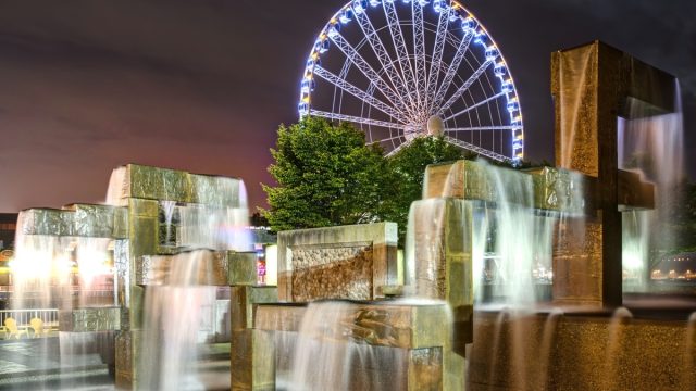 Vibrant Lights Illuminate Modern Fountain Sculpture in Night Scene with Seattle Great Wheel in Seattle, Washington
