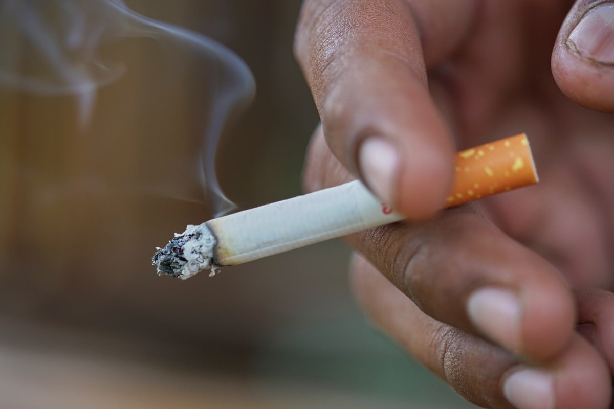 Close up man hand smoking cigarette.