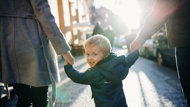 parents holding hands with their kid
