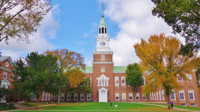 Looking down the Dartmouth Green with trees beginning to show fall colors and a blue sky with puffy white clouds on a nice autumn day the Baker Library and its bell tower is in the background. - Image