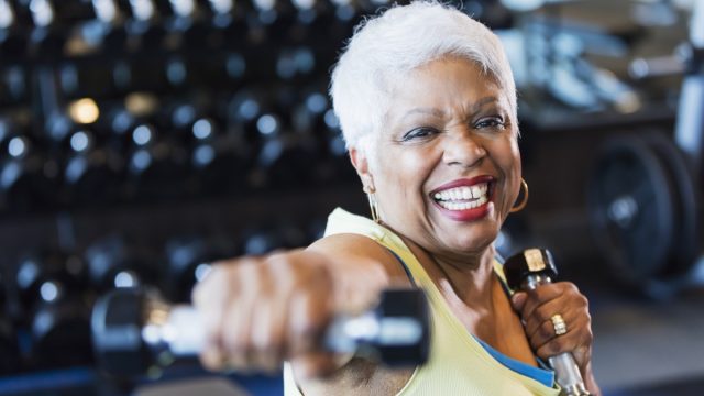 Older woman lifting weights at the gym