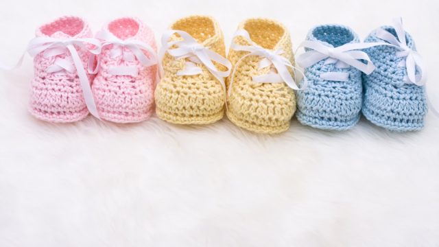Three pairs of baby shoes, representing three children