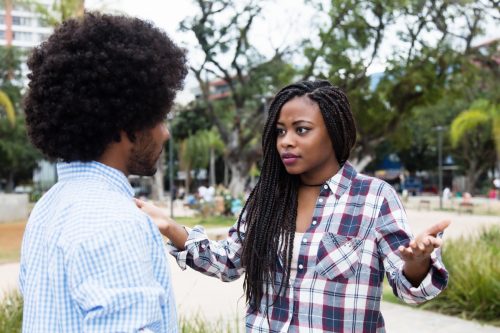 black woman throwing up hands in annoyance at black man