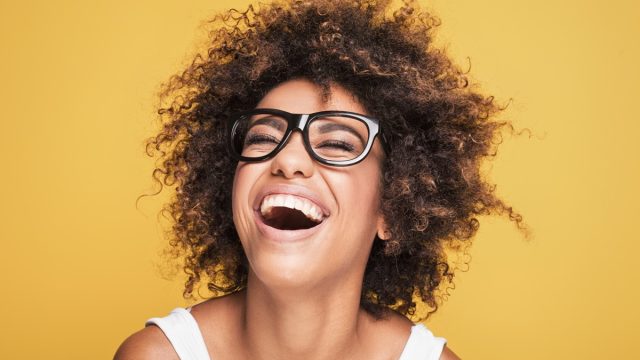 woman laughing on gold background, what do you call jokes