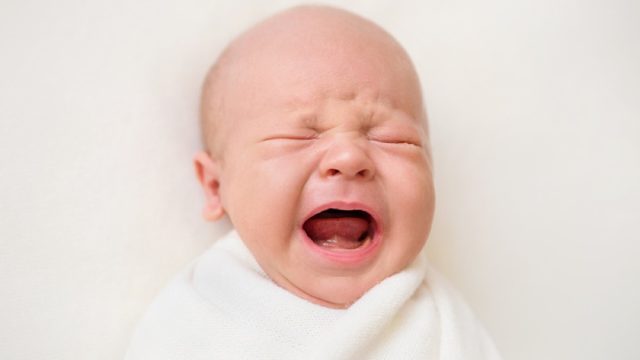 crying newborn baby in swaddle, parenting tips