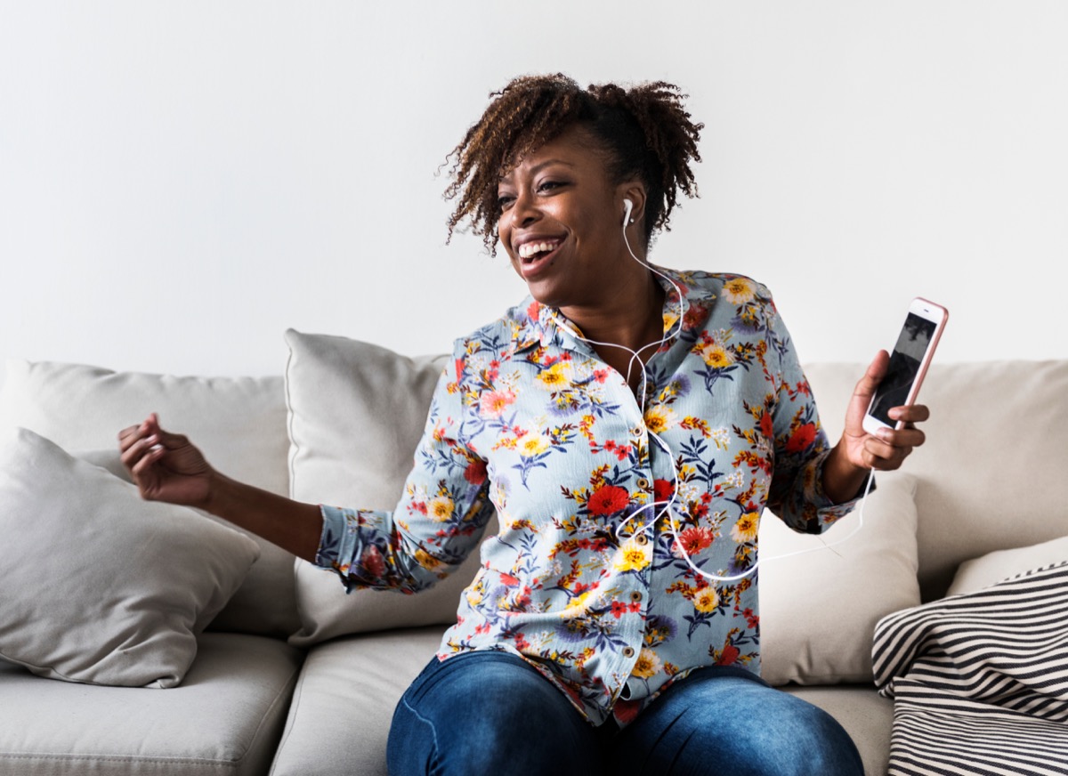 woman dancing alone listening to music with her headphones, ways to feel amazing