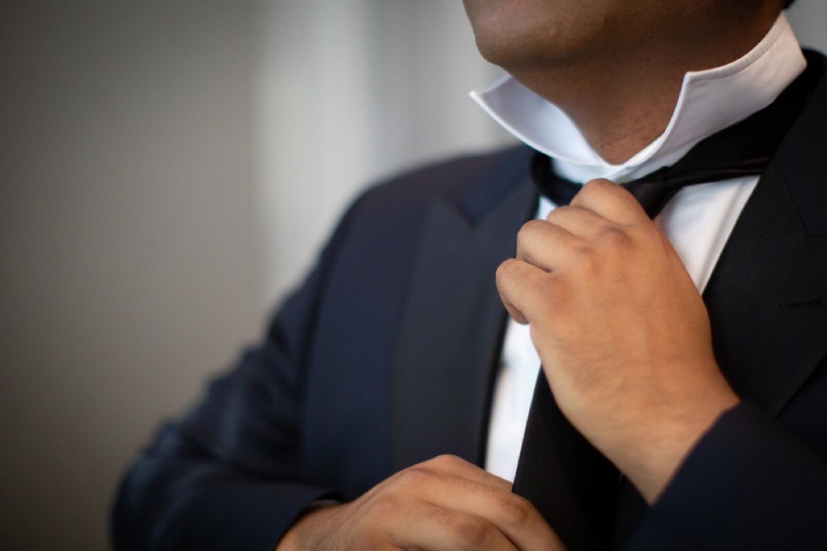older man tying tie, office etiquette