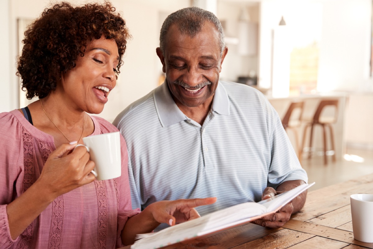 couple looking through photo album over coffee, ways to feel amazing