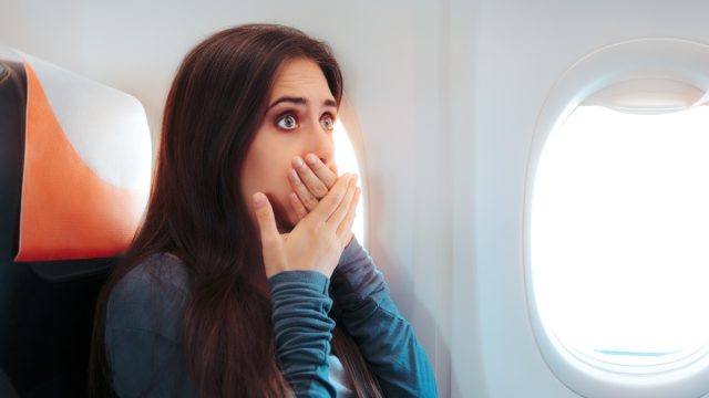 woman with motion sickness on airplane
