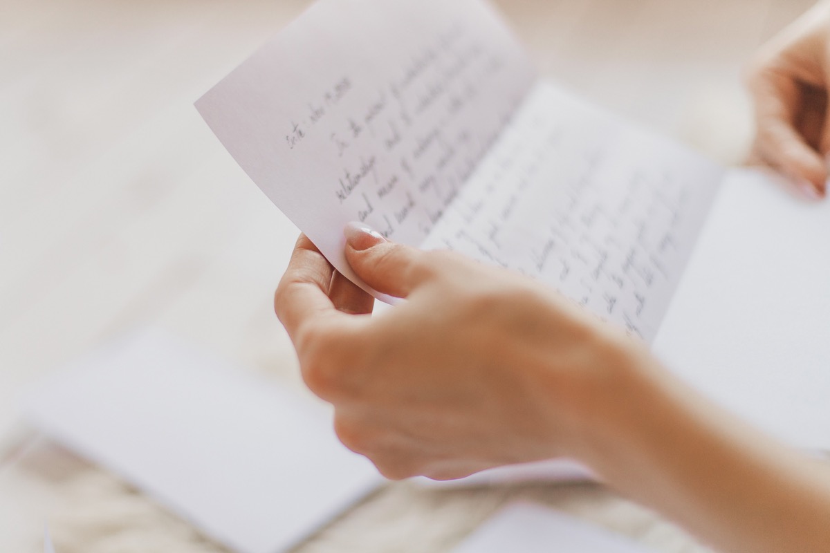 Closeup of woman's hand holding letter, spouse left while pregnant
