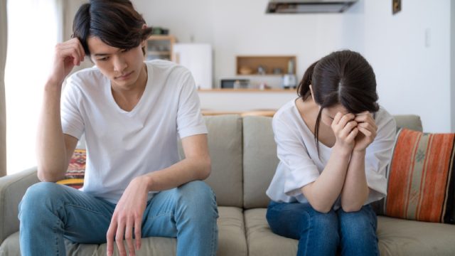 asian couple fighting on couch