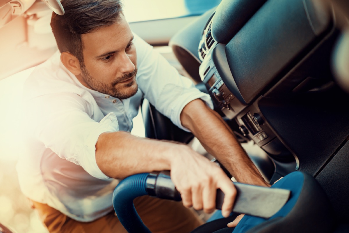 man vacuuming car with precision attachment, vacuuming tips