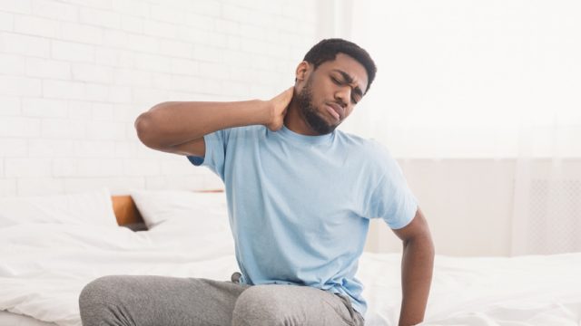 man with neck and back pain, signs your cold is serious