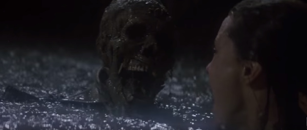 woman surrounded in the muddy waters by skeletons