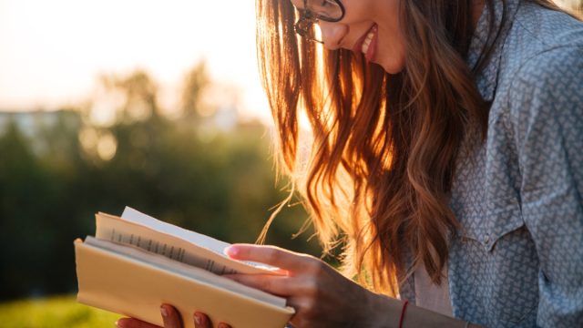 girl reading book or dictionary, new words coined