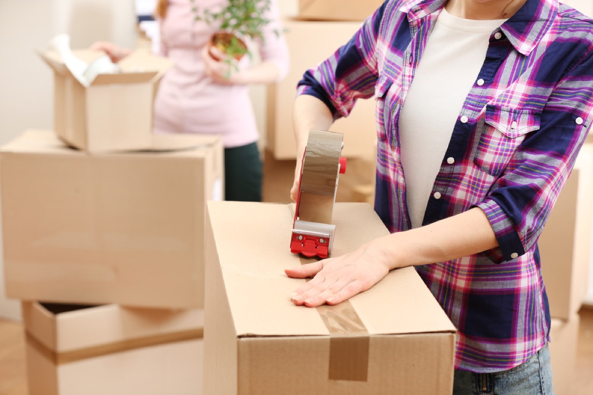 women taping moving boxes, things you should never store in your attic