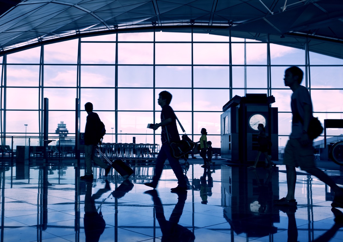 Passengers walking through airport terminal at dusk