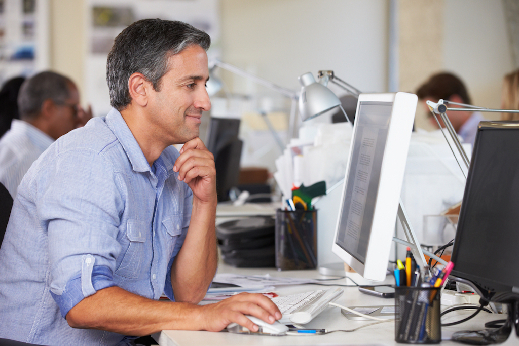 happy middle-aged man working in office procrastinate productively