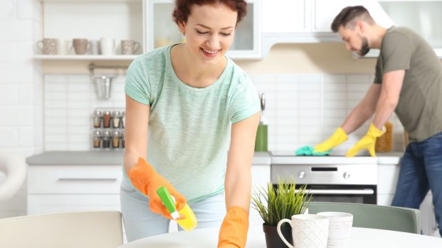 white couple cleaning kitchen in modern home