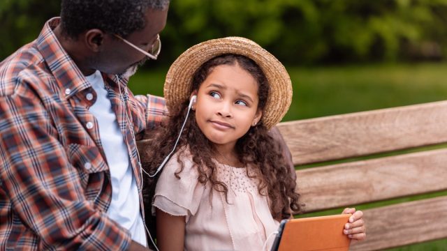 grandchild listening to music with grandfather