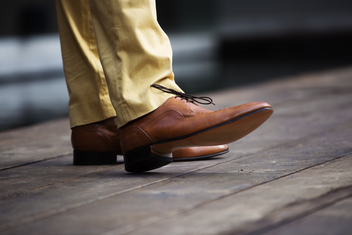 Mans legs in brown leather shoes shot from below the knee