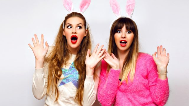 Two women taking a photograph wearing bunny ears