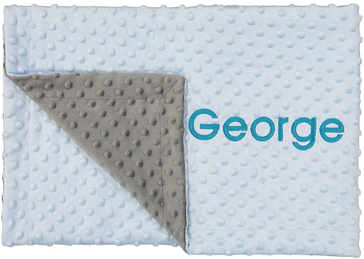 blue nubbly baby blanket with "george" embroidered on it in blue