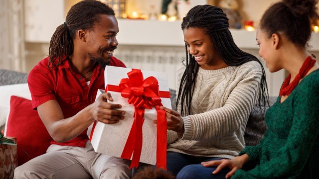 Man giving a Christmas present to his grateful friend or girlfriend