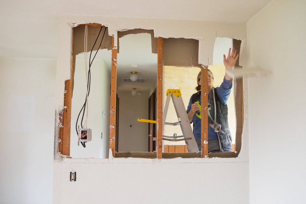 woman knocking down a wall in her house