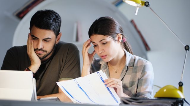 Young couple reviewing invoices and doing family business plan. Concept of money and economic problem for man and woman living together (Young couple reviewing invoices and doing family business plan. Concept of money and economic problem for man and