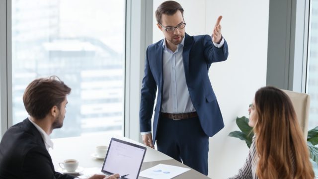 white male coworker yelling at younger female and male office employees
