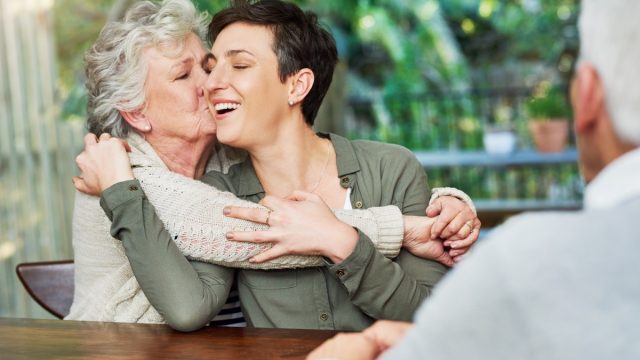 older woman kissing adult duaghter