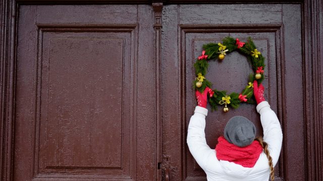 Person hanging Christmas wreath