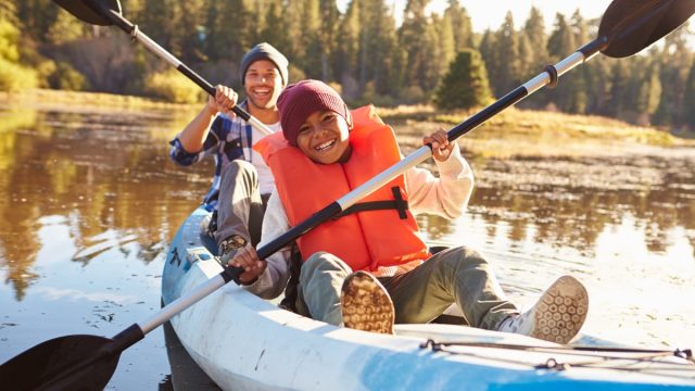 black father and son kayaking