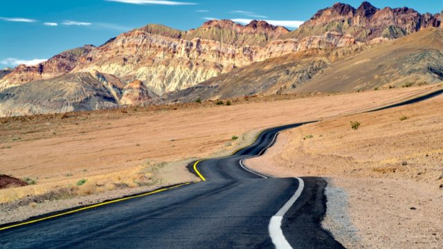desert road leads into cliffs in california