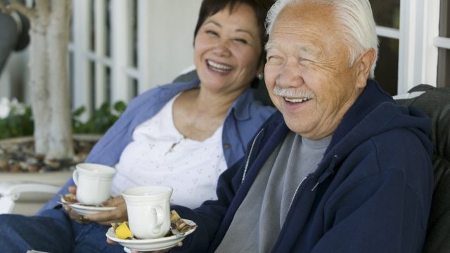 older asian couple drinking tea outdoors