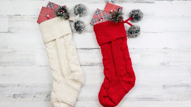 red and white cable knit christmas stockings on white background