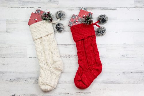 red and white cable knit christmas stockings on white background