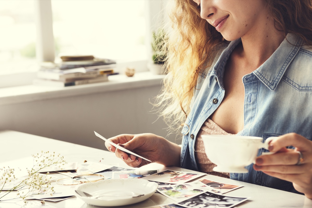woman reminiscing with old photographs at home