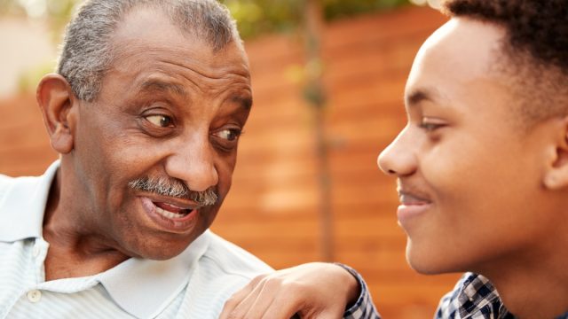 black grandfather talking to teenage grandson