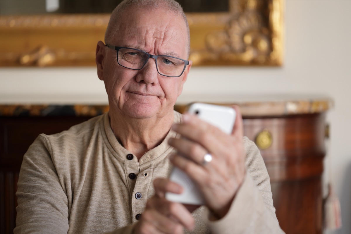 senior man having trouble with his phone.