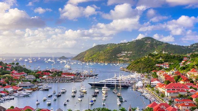 a view of the harbor, boats, and mountains of st. barts