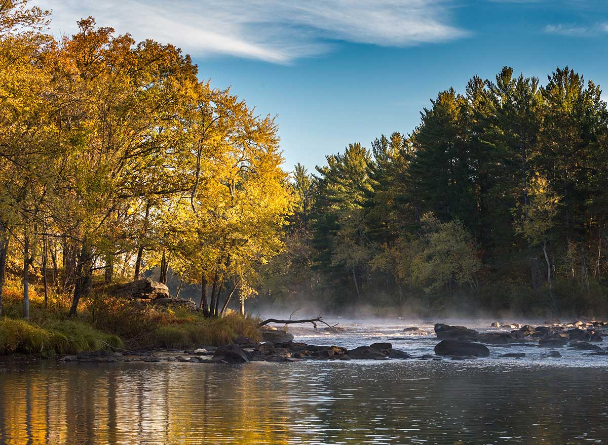 river with mist coming off of it during fall foliage